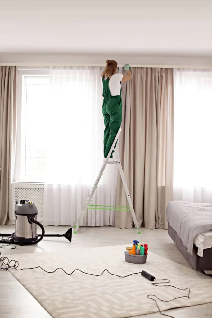 Expert short-term rental cleaning in Manchester – cleaner sanitising high surfaces in bedroom