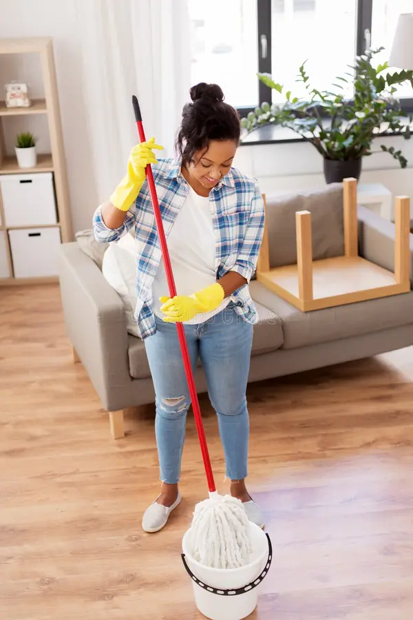 Manchester cleaning services employee mopping a commercial hallway next to a wet floor sign.